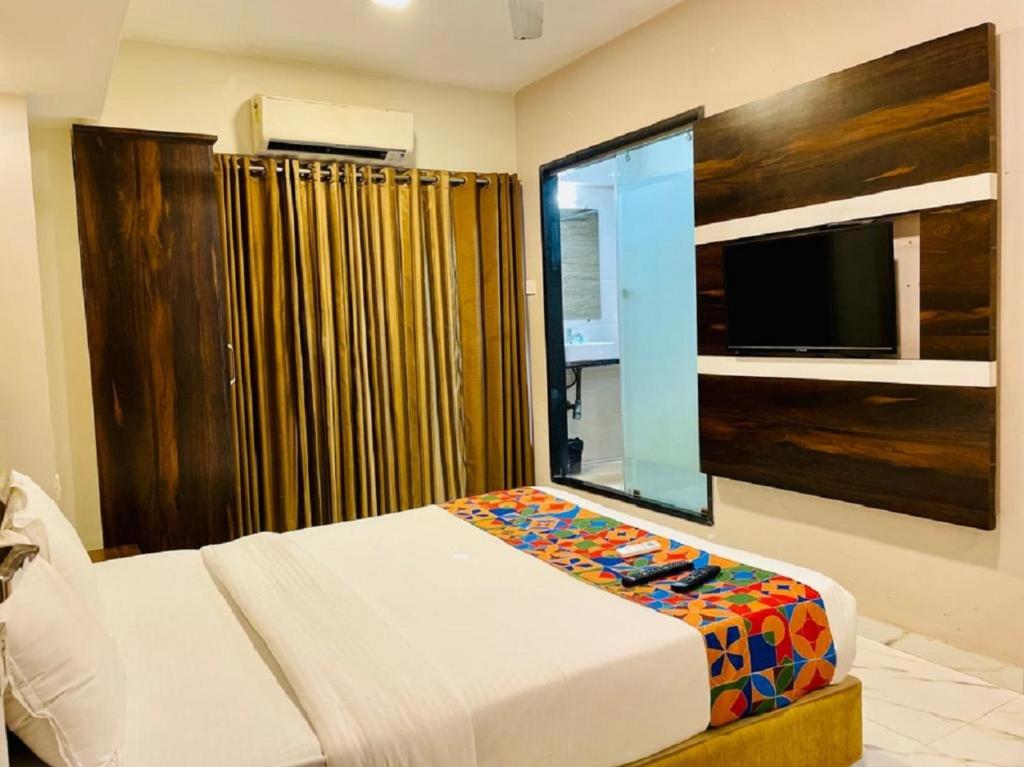 孟买Hotel Embassy Park - BKC Mumbai的一间卧室设有一张床,大窗户配有电视