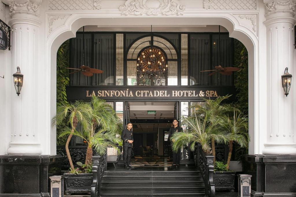 河内La Sinfonía Citadel Hotel and Spa的站在酒店入口处的男人