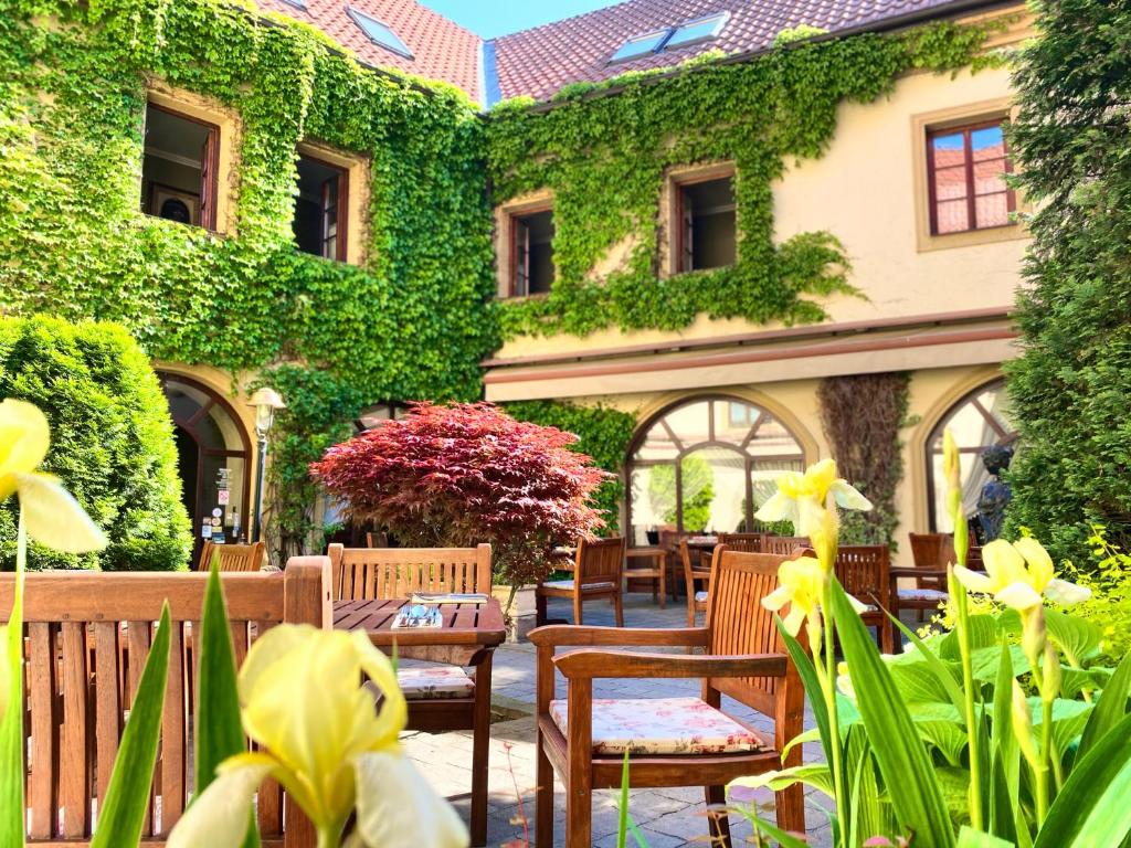 克罗梅日什Hotel Octarna - Free parking的常春藤覆盖着椅子和鲜花的建筑