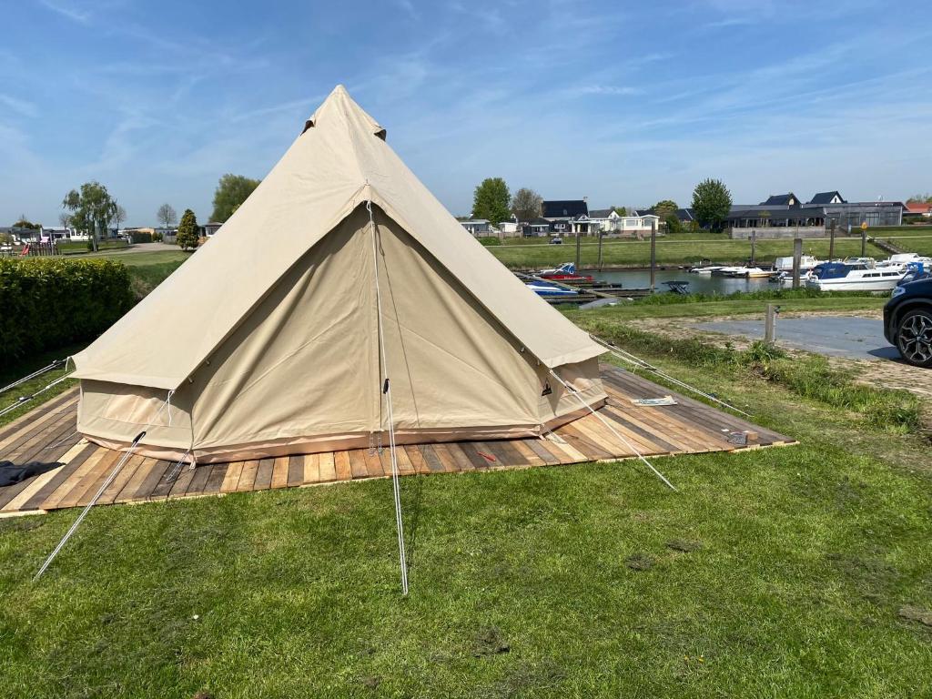 HeerewaardenBell Tent aan de haven的坐在草地上的大棕褐色帐篷