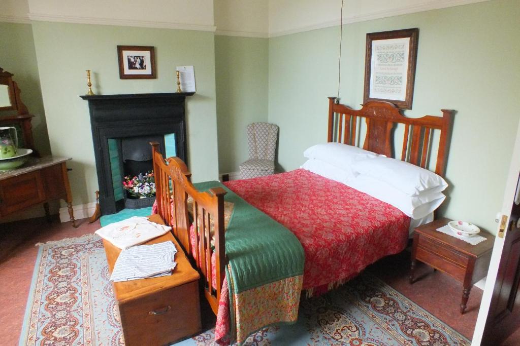 斯旺西狄兰托马斯乡村民宿的一间卧室配有一张床和一个壁炉