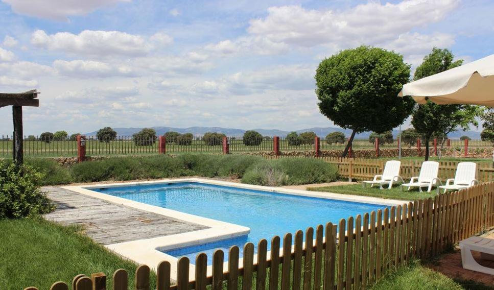 Arenas de San JuanLos Mentideros的一个带椅子和围栏的庭院内的游泳池