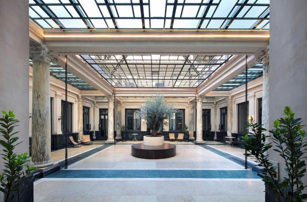 都灵Agora' - Boutique Stays的大型大堂设有玻璃天花板和植物