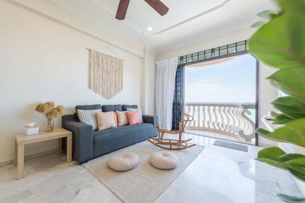 波德申PortDickson Cozy Muji Home 10Pax3BR 1min to beach的一间带蓝色沙发的客厅和一个阳台