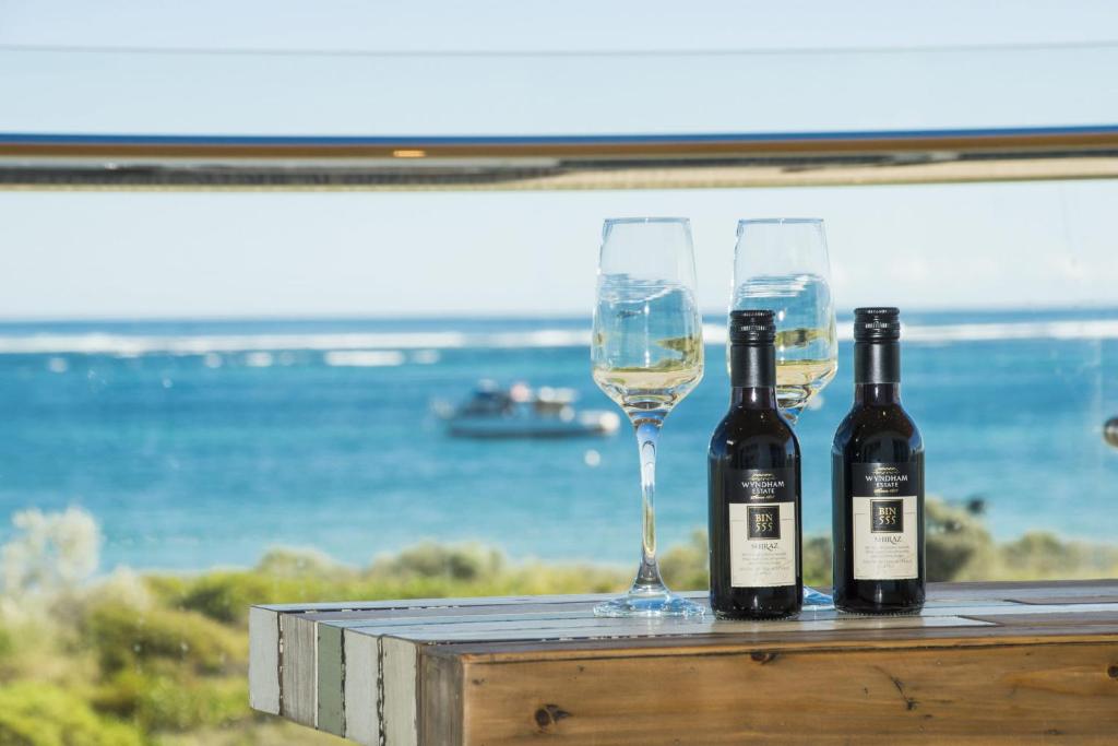 兰斯林Oceans View - Luxury Apartment with ocean views的2瓶葡萄酒和2杯桌子上的酒