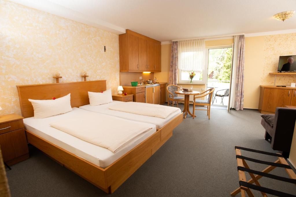 Waldkappel斯特恩兰德酒店的一间卧室配有一张大床和一张桌子
