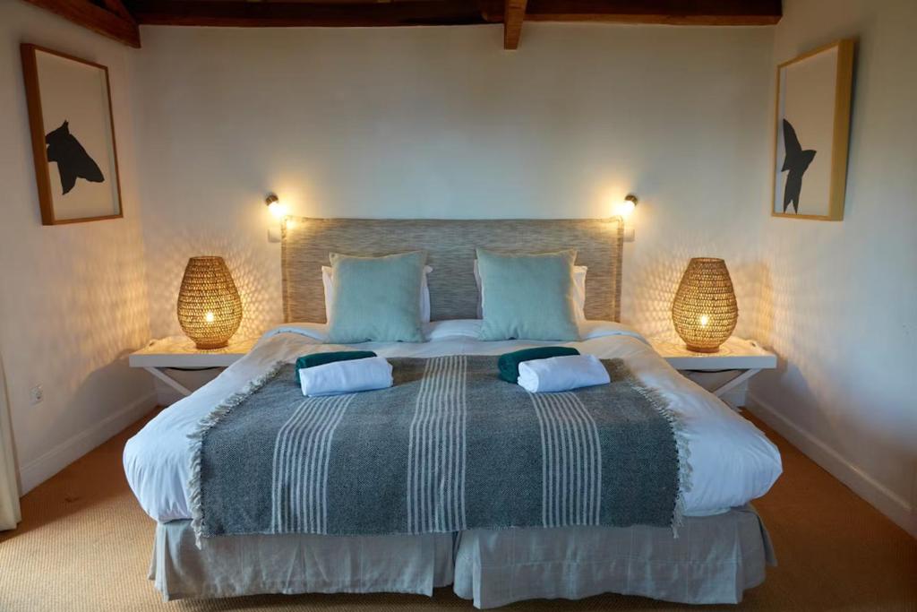 卡列塔葡萄园农场酒店的一间卧室配有一张大床和两盏灯