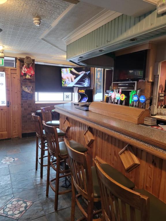 DromoreO'Connors Bar Restaurant and Guesthouse的一间酒吧,餐厅里摆放着一排木椅