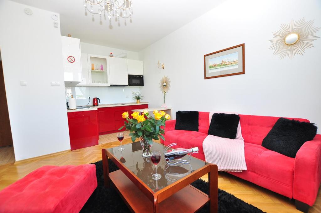 托伦Apartament Chełmiński的客厅配有红色的沙发和桌子