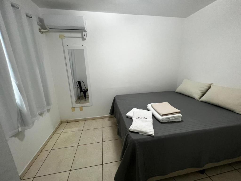 大坎皮纳Apartamentos da Thay的一间卧室配有一张床,上面有两条毛巾