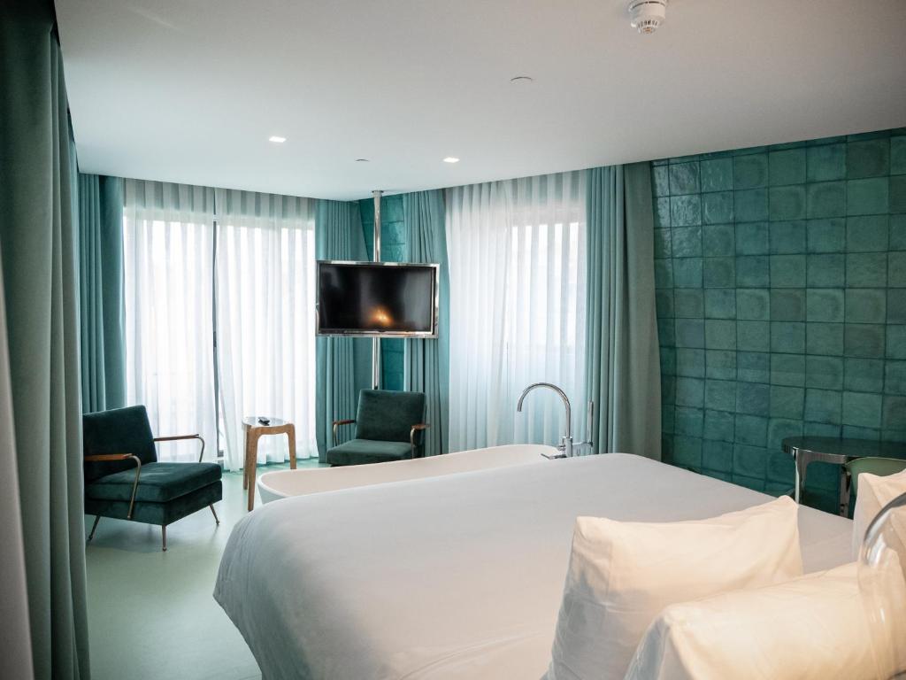 里斯本WC精品酒店的酒店客房设有一张床和墙上的电视
