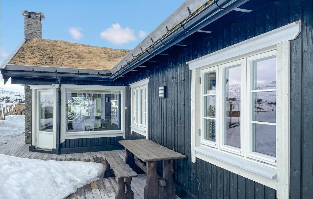 弗洛Beautiful Home In Fl With Sauna的蓝色的房子,甲板上设有长凳