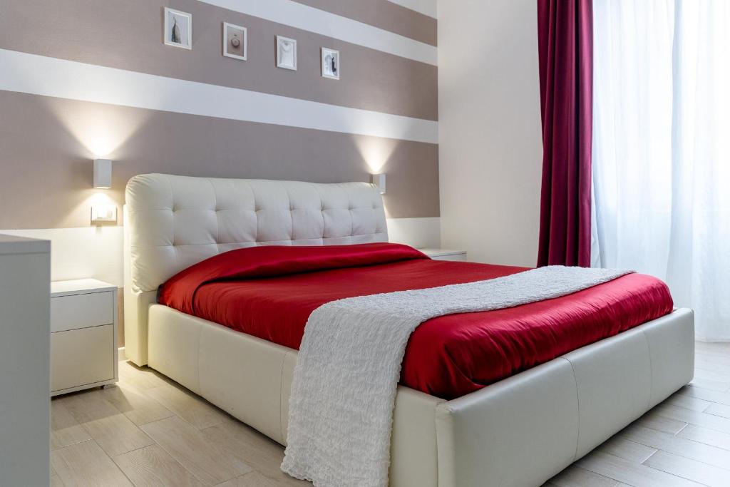 斯培西亚Myro's House的卧室配有一张带红色毯子的白色床