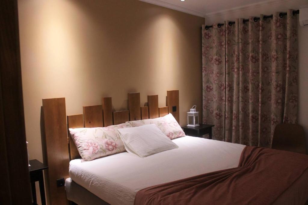 Casa do Centro的一间卧室配有一张大床和木制床头板