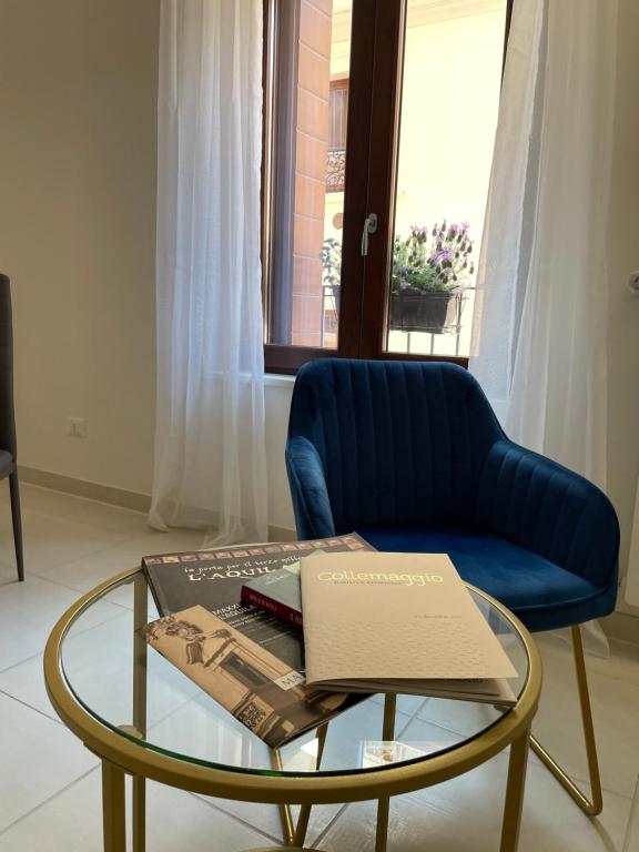 拉奎拉B & B Piazza Angioina的客厅配有蓝色椅子和玻璃桌