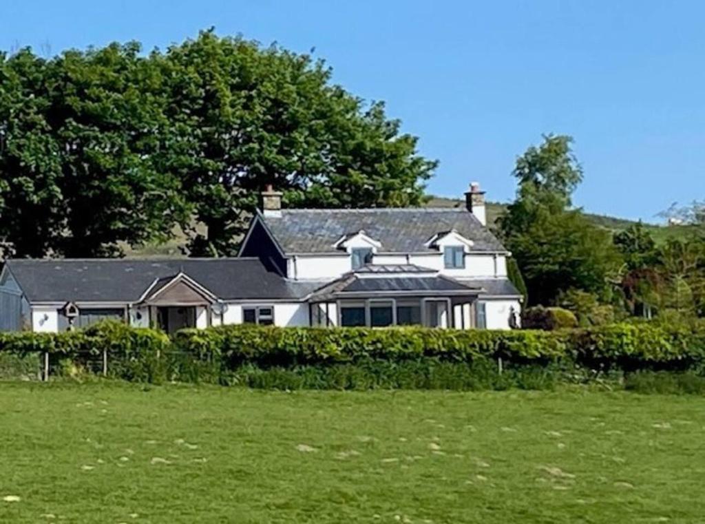 HirnantTranquil 3-Bed Cottage Near Lake Vyrnwy的前面有绿地的白色房子