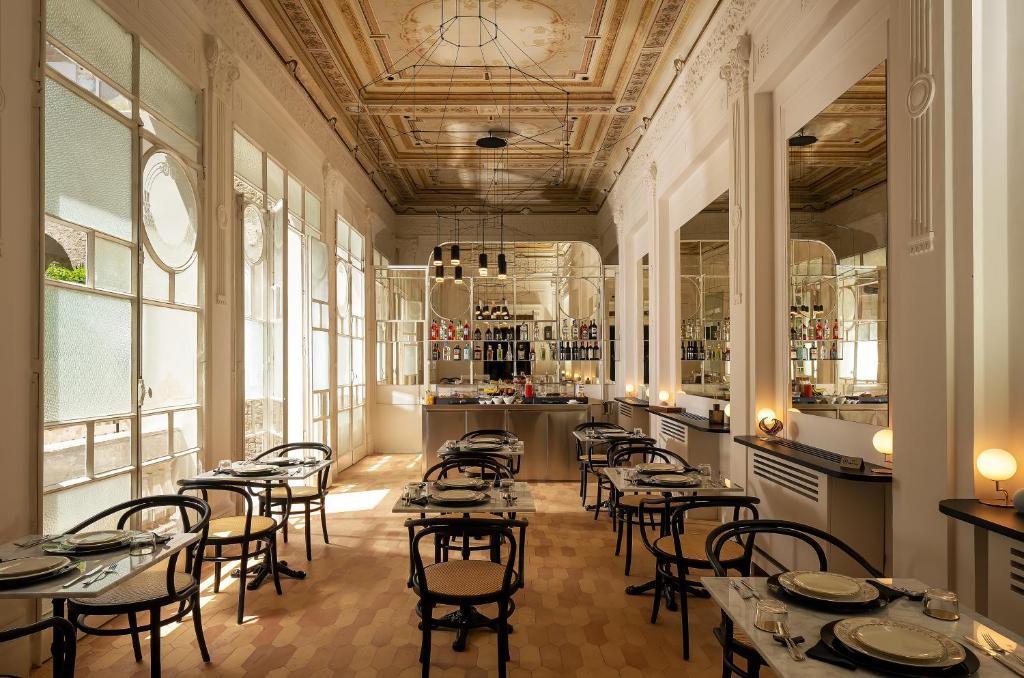 那不勒斯Artemisia Domus - Giardino的一间设有桌椅的餐厅,位于带窗户的房间内