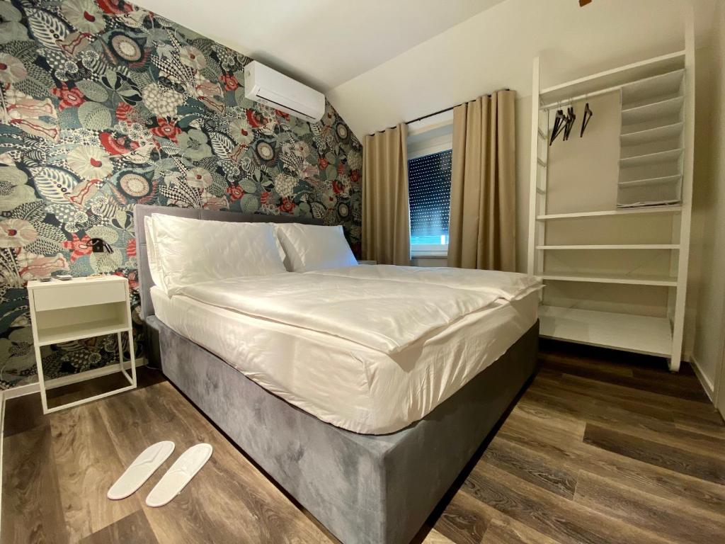 ZbiljeBoutique hotel ZBILJE的一间卧室配有一张带花卉墙壁的床