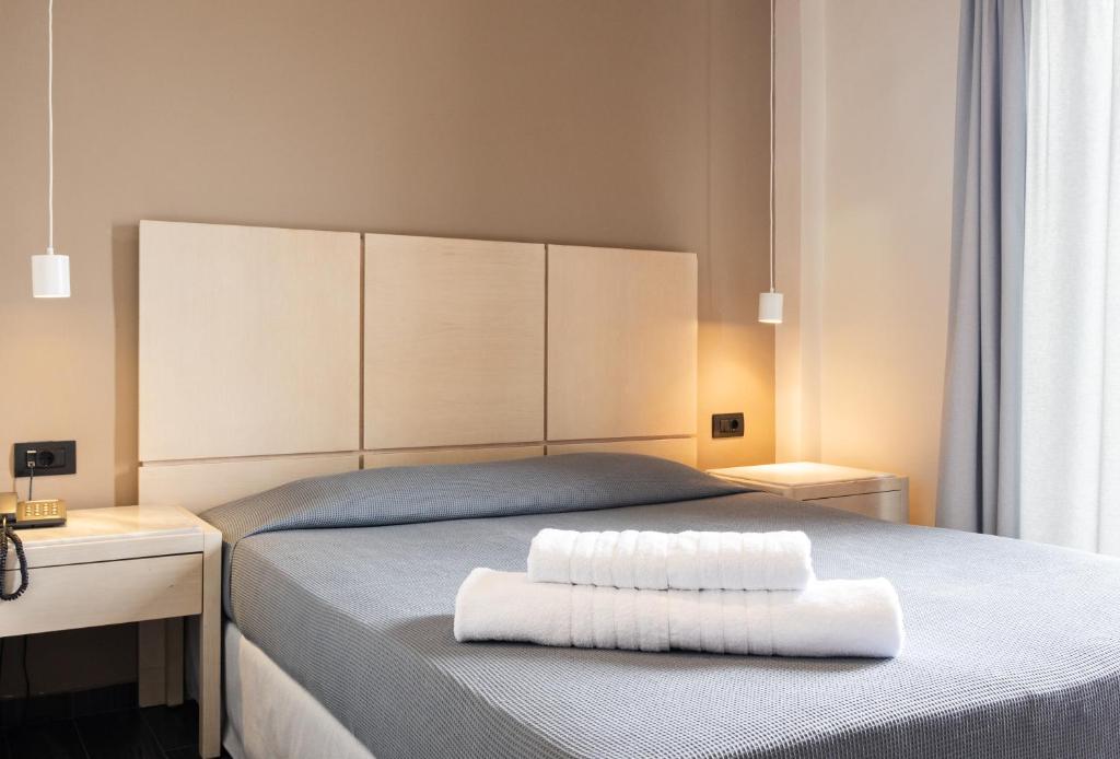 路特奇广场酒店的一间卧室配有一张带两条白色毛巾的床
