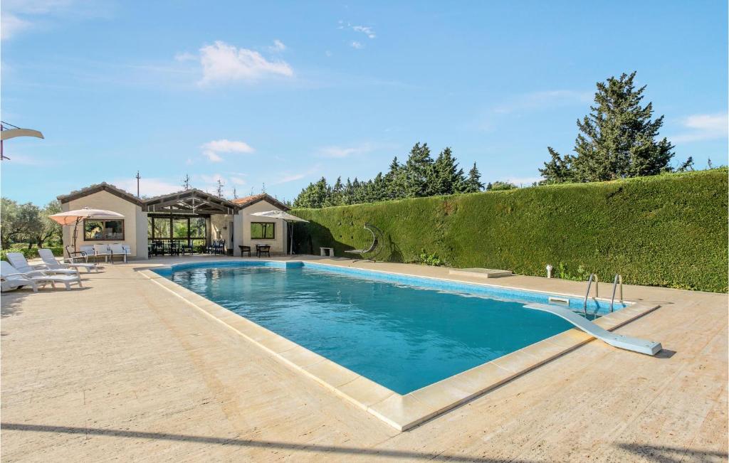 科米索Lovely Home In Comiso With House A Panoramic View的一座房子后院的游泳池