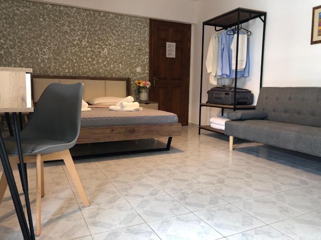 斯基亚索斯镇Armonia Guest House Skiathos的一间卧室配有一张床、一张沙发和一把椅子