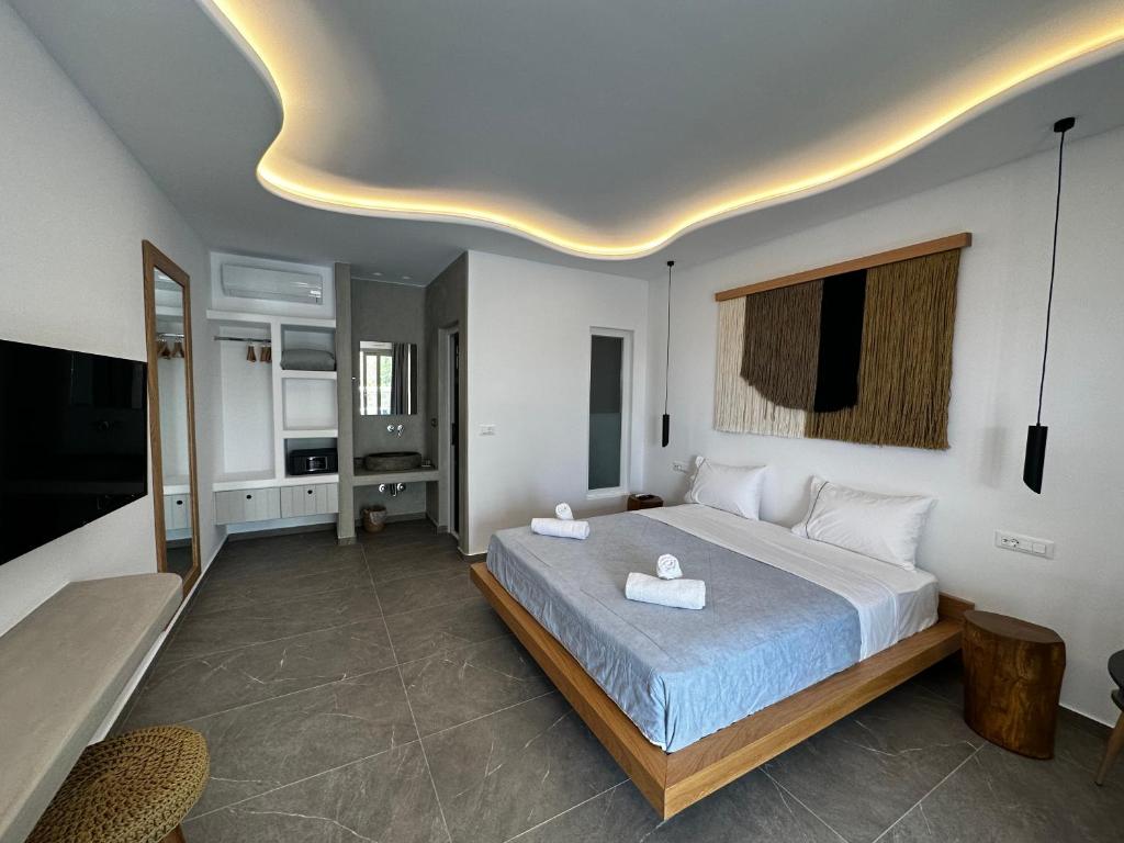 米克诺斯城Abelos Mykonos的一间卧室设有一张大床和天花板