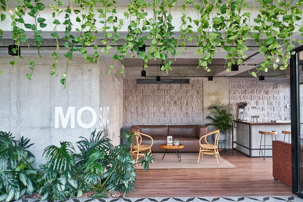 巴兰基亚Mosaic Studios Buenavista的大堂配有沙发、椅子和植物