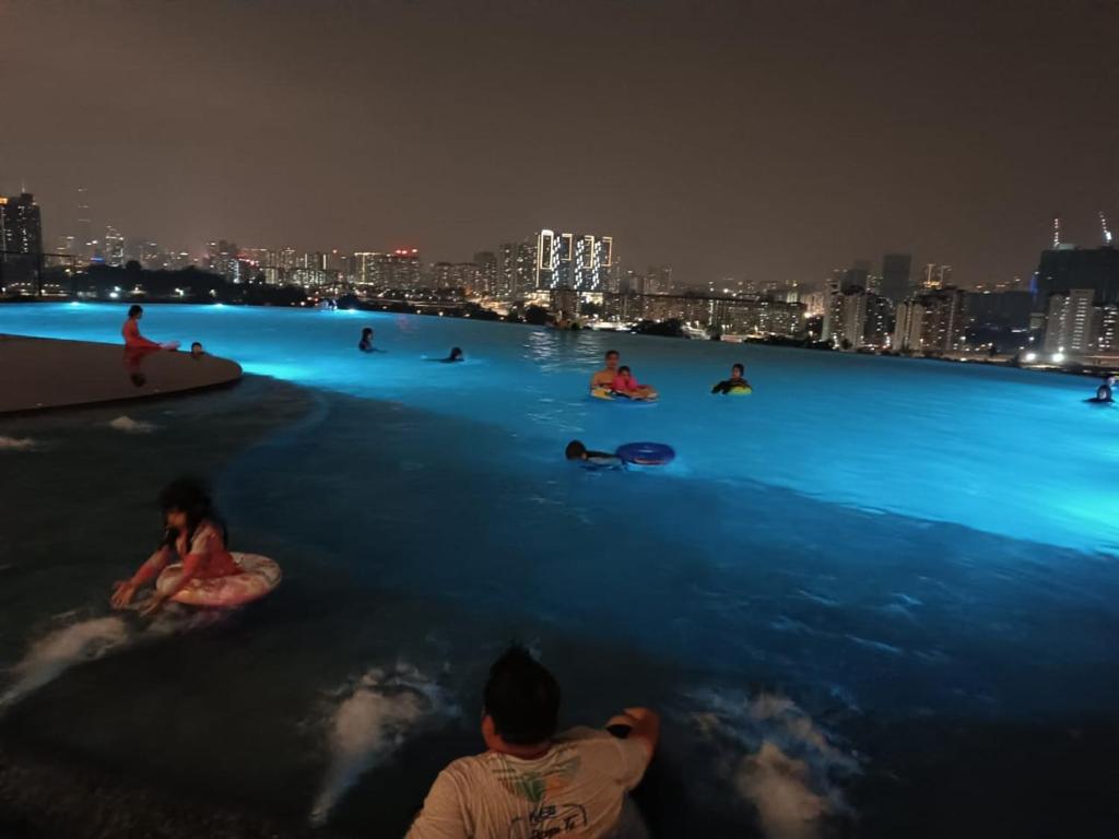 吉隆坡Mikael Homestay Kuala Lumpur的一群人晚上坐在水里