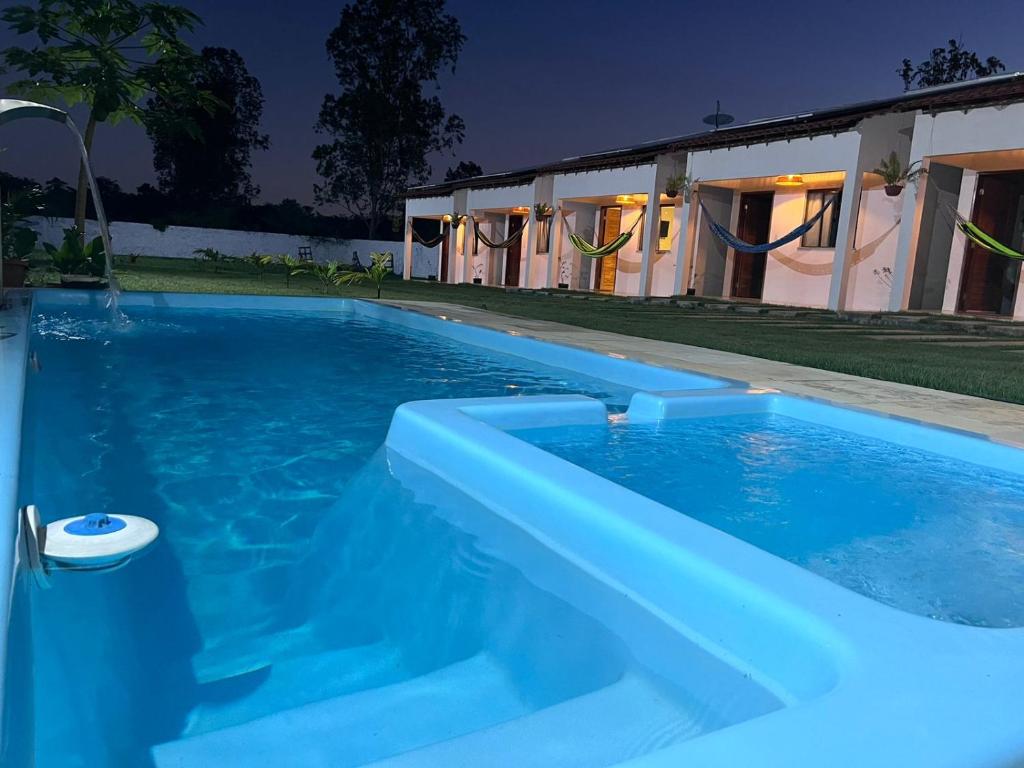 巴雷里尼亚斯Pousada Mangaba的房子前面的蓝色游泳池