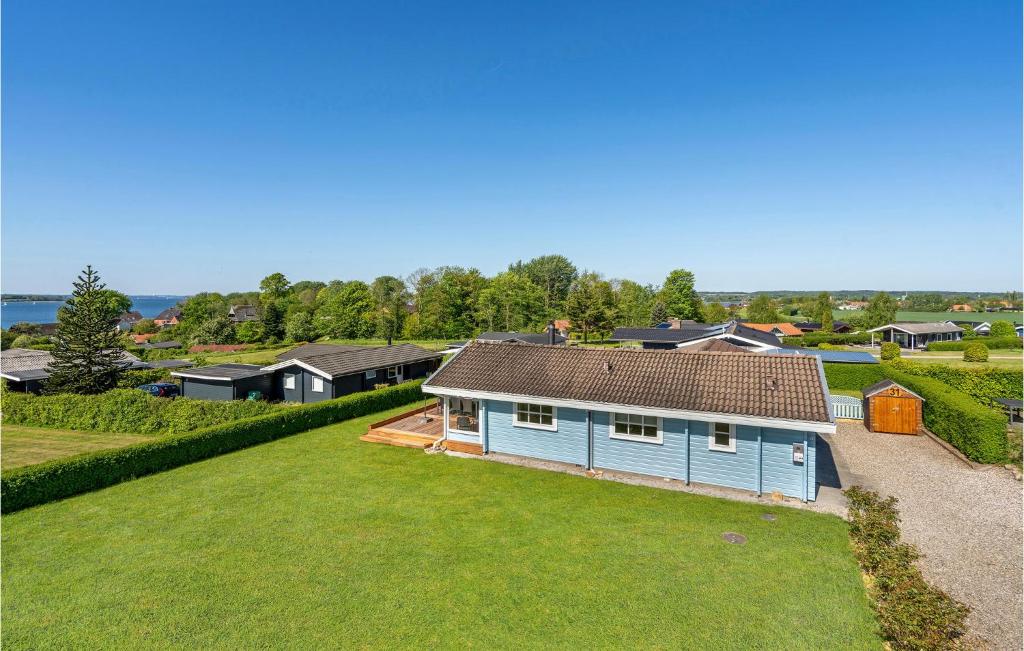 艾恩松Amazing Home In Egernsund With House A Panoramic View的享有蓝色房子空中美景,设有庭院