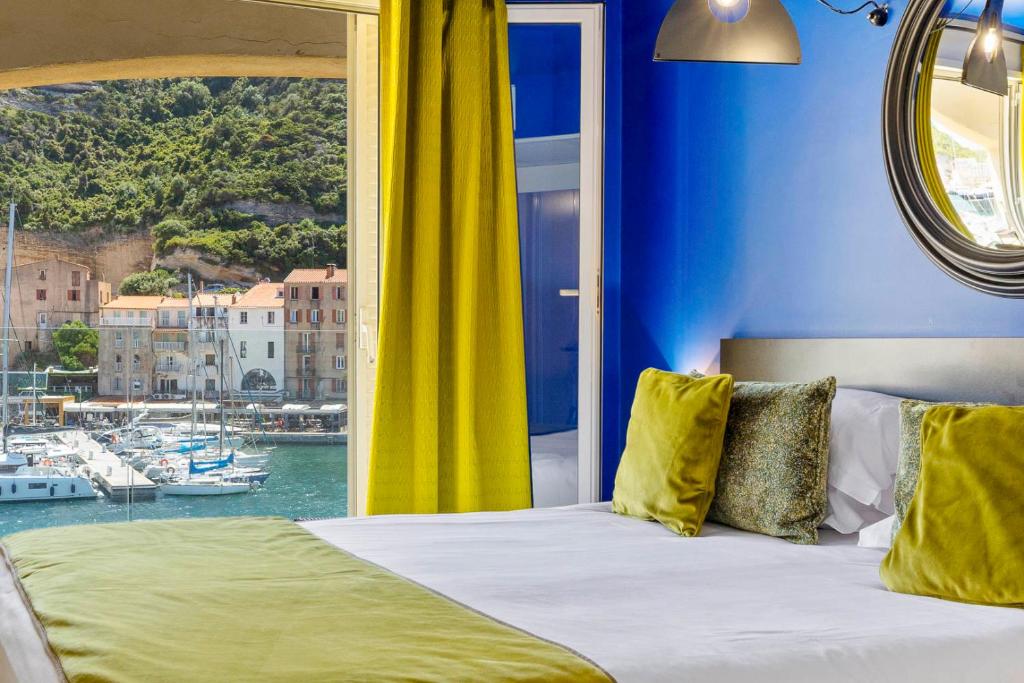 博尼法乔索勒马尔酒店的一间卧室设有一张床,享有海港景色