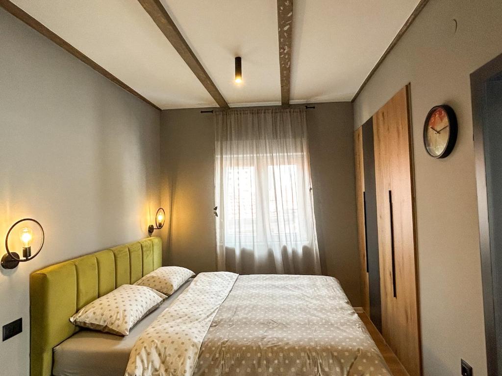 莫斯塔尔Old Town Premium Apartments的一间卧室配有一张带黄色床头板的床和窗户