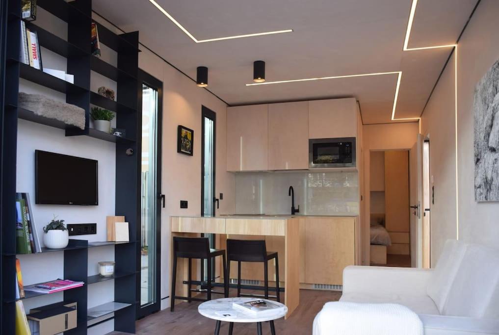 鹿特丹tiny house的一间带白色沙发的客厅和一间厨房