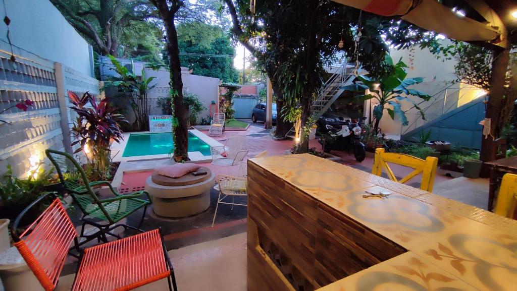 亚松森Taguato B & B的一个带桌椅的庭院和一个游泳池