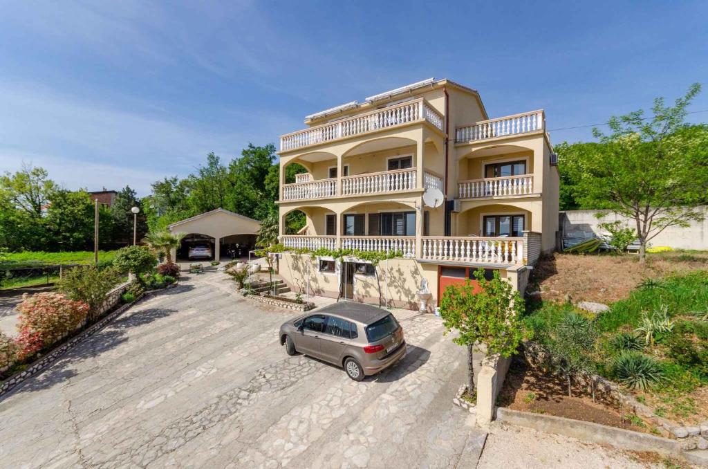 德拉马利Two-Bedroom Apartment Crikvenica near Sea 12的停在大房子前面的汽车