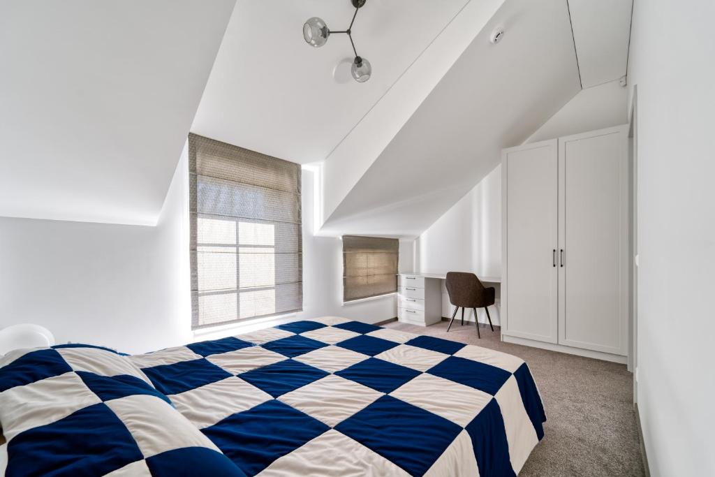 卡尔克尔Karklės Oazė的卧室配有蓝色和白色的格子床