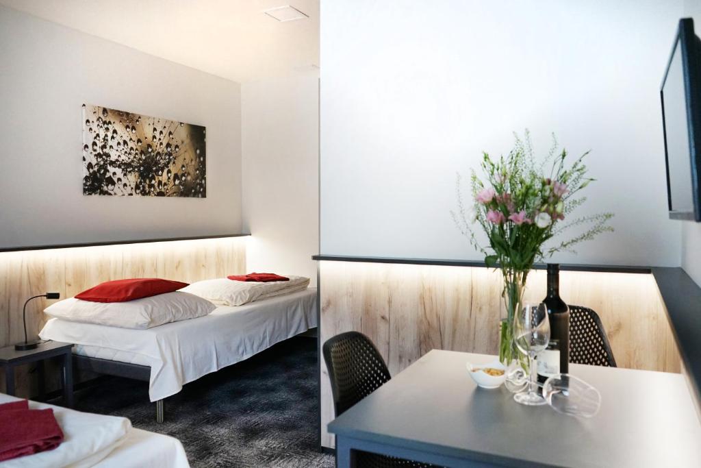 布尔诺微笑旅馆的酒店客房,设有两张床和一张鲜花桌。