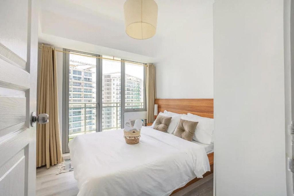 马尼拉Adam's Crib Apartment 2BR by Azure Residences Near Airport的卧室配有白色的床和大窗户