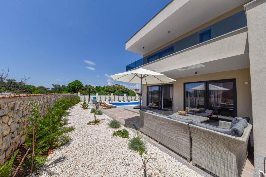 希贝尼克Villa Adriatic Sunrise的房屋设有带遮阳伞的户外庭院