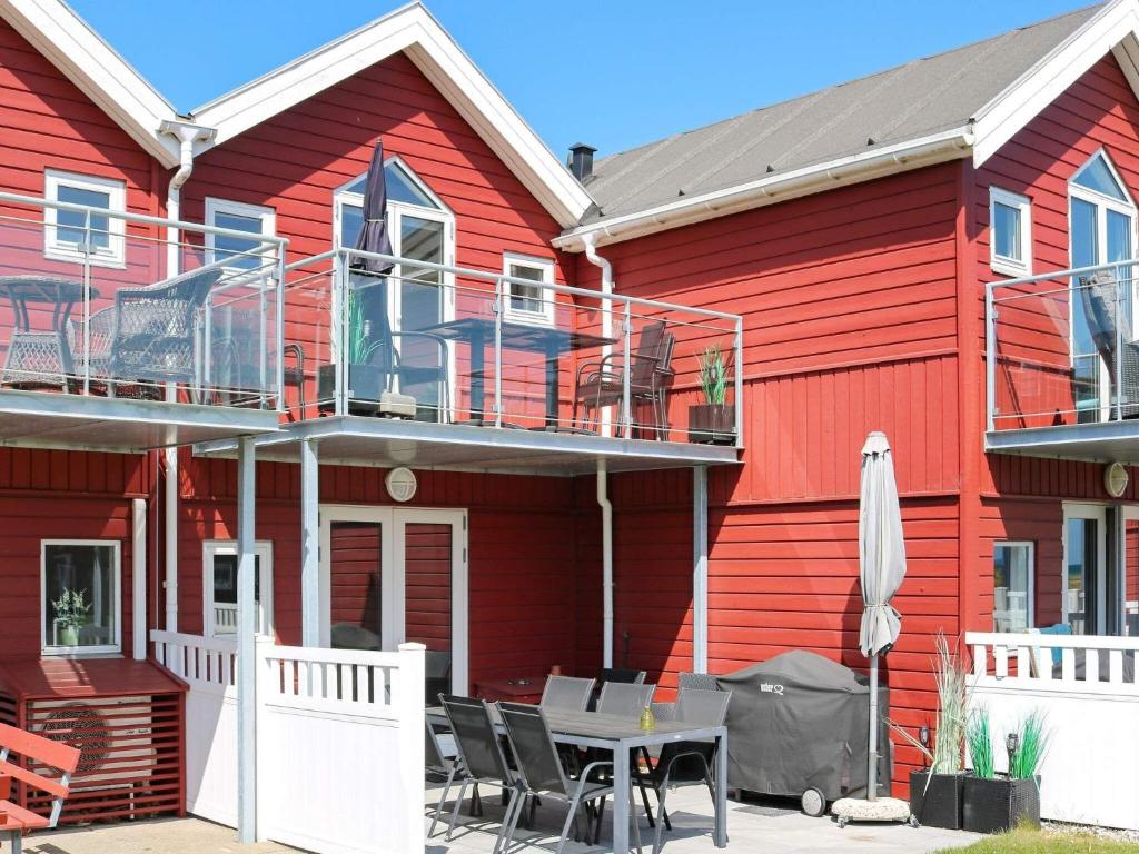 诺尔赫鲁普Two-Bedroom Holiday home in Hadsund 11的前面有一张桌子和椅子的红色房子
