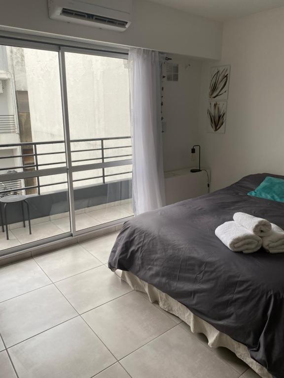 罗萨里奥Hermoso Monoambiente en Rosario的一间卧室设有一张床和一个大窗户