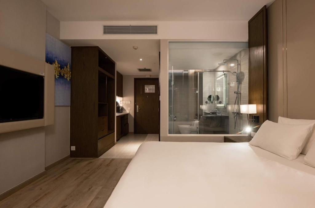 芽庄Panorama Apartment Nha Trang的卧室配有一张白色大床和电视。