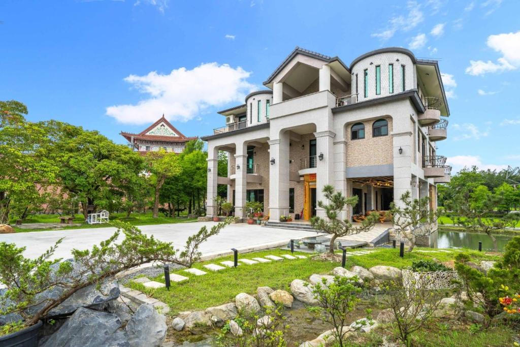 Yilan City森堡休閒莊園的一座白色的大房子,前面设有一个花园