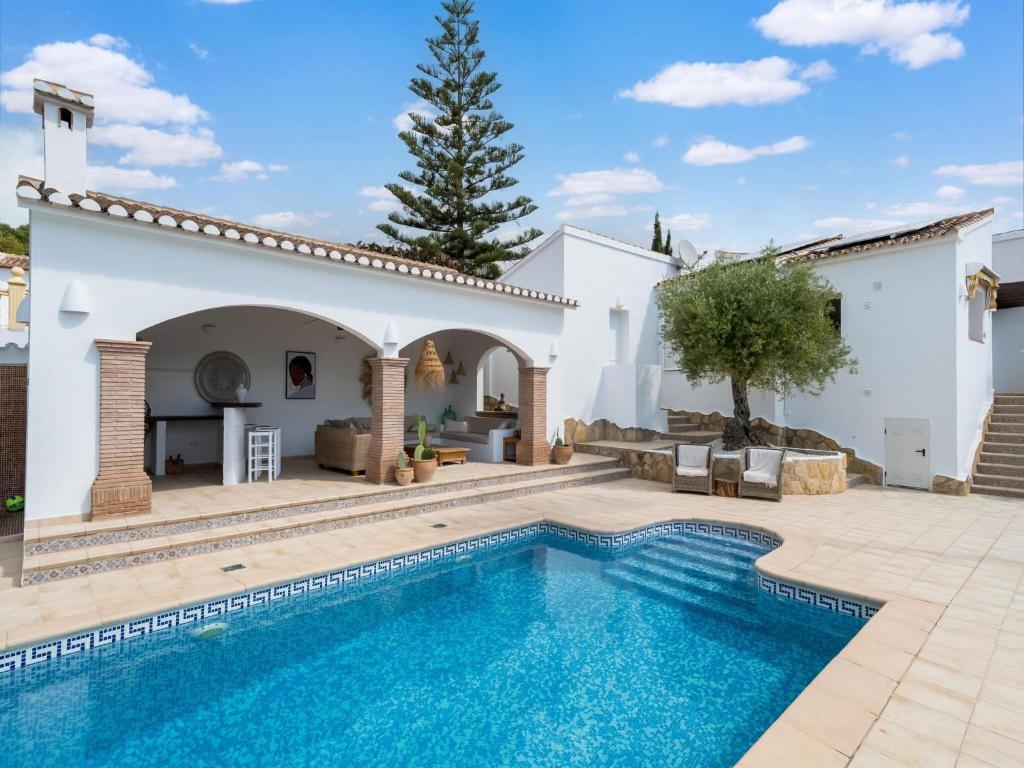 莫莱拉Belvilla by OYO El Para so的一座带游泳池和庭院的别墅