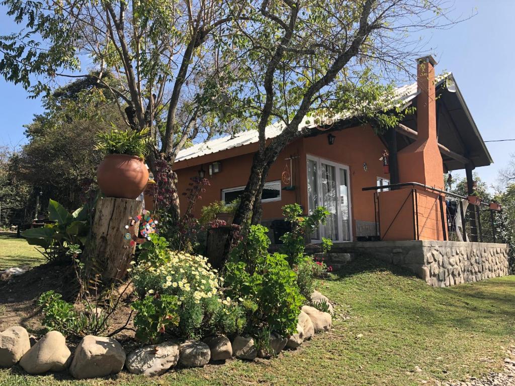 萨尔塔Wara Kusi cottages, in Salta Argentina的前面有花园的房子