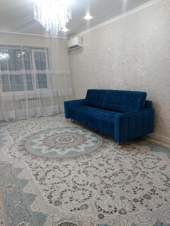 乌拉尔斯克Абая 244的客厅里一张蓝色的沙发,铺着地毯