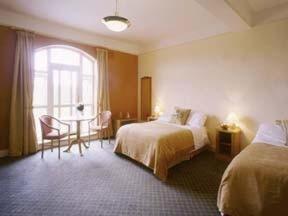 沃特福德林地休闲中心酒店的酒店客房设有两张床、一张桌子和一个窗户。