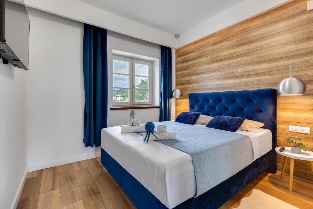 萨利TEONA Luxury Apartment with terrace的一间卧室设有蓝色的床和窗户。