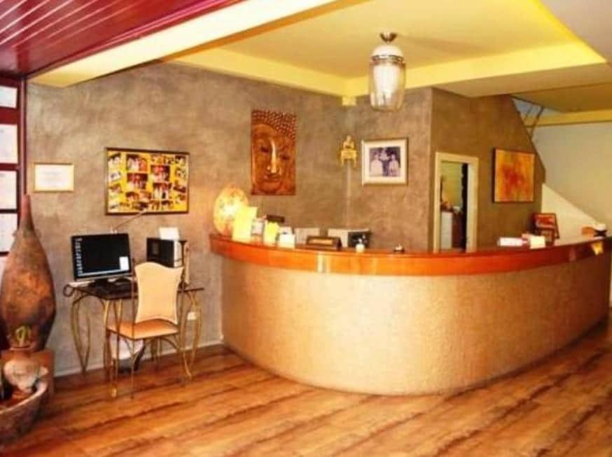 芭堤雅市中心Pasadena Lodge的一间酒吧,房间配有一张带笔记本电脑的书桌