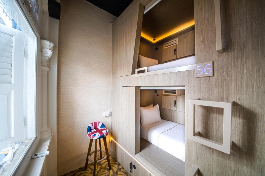 新加坡CUBE Boutique Capsule Hotel at Kampong Glam的一间小房间,房间内设有一张双层床